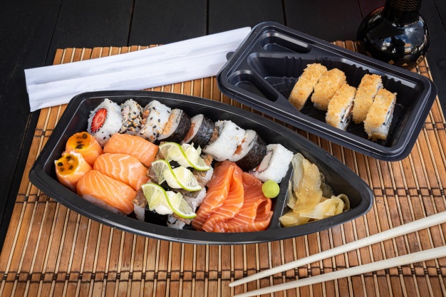 Sushi no prato na mesa preta